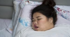Übergewichtige Frau schläft mit offenem Mund